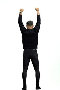 A man, full-length, on a white background, raised his hands up.