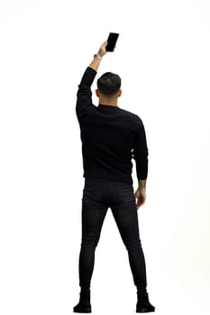 A man, full-length, on a white background, waving his phone.