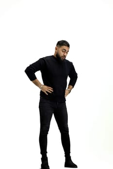 Man, full-length, on a white background, hands on hips.