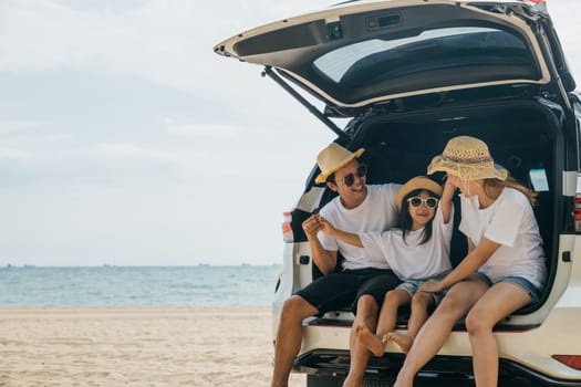 People enjoying road trip sitting down on back their car, Parents and children traveling in holiday at sea beach, family having fun in summer vacation on beach, Happy Family and World Tourism Day