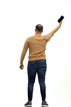 A man, full-length, on a white background, waving his phone.