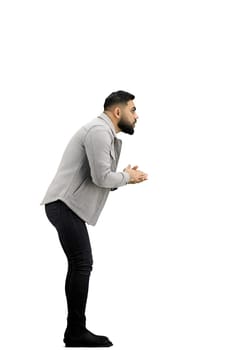 A man, full-length, on a white background, rubs his hands.