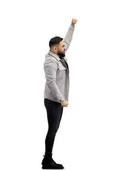 A man, full-length, on a white background, raised his hand up.