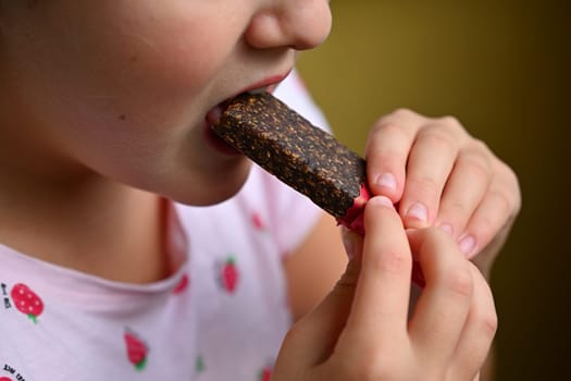 Young girl - child eating candy and sweets. Detail of face and mouth. Concept for healthy lifestyle - healthy - unhealthy sweet food and sugar.