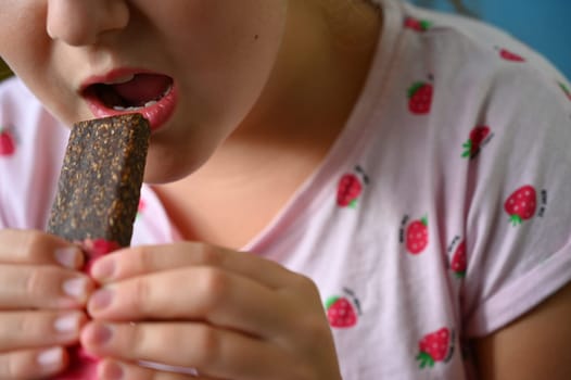 Young girl - child eating candy and sweets. Detail of face and mouth. Concept for healthy lifestyle - healthy - unhealthy sweet food and sugar.