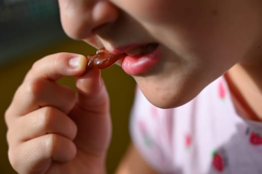 Young girl - child eating candy and sweets. Detail of face and mouth. Concept for healthy lifestyle - healthy - unhealthy sweet food and sugar.