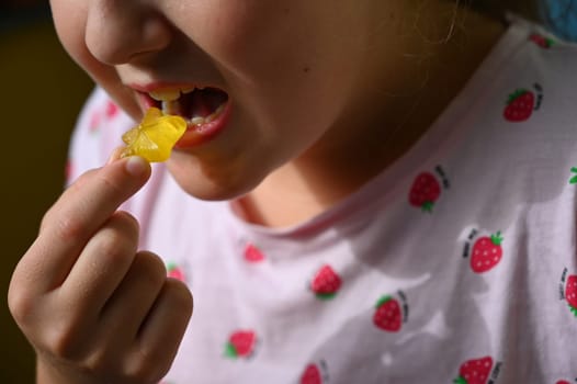 Young girl - child eating candy and sweets. Detail of face and mouth. Concept for healthy lifestyle - healthy - unhealthy sweet food and sugar.