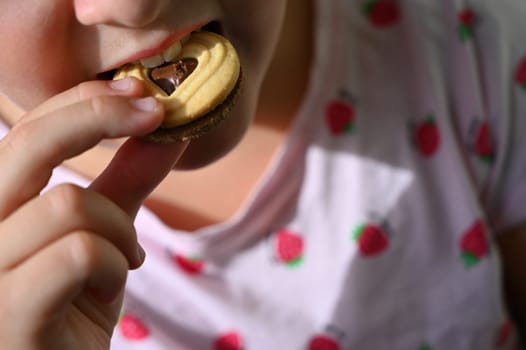 Young girl - child eating candy and sweets. Detail of face and mouth. Concept for healthy lifestyle - healthy - unhealthy sweet food and sugar.