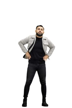 Man, full-length, on a white background, hands on hips.