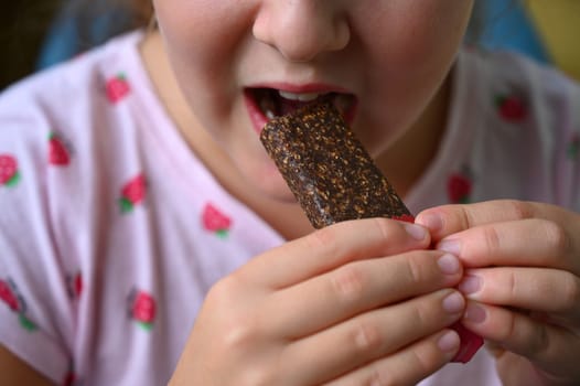 Young girl - child eating candy and sweets. Detail of face and mouth. Concept for healthy lifestyle - healthy - unhealthy sweet food and sugar.