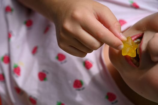 Young girl - child eating candy and sweets. Detail of face and mouth. Concept for healthy lifestyle - healthy - unhealthy sweet food and sugar.