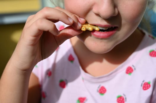 Young girl - child eating candy and sweets. Detail of face and mouth. Concept for healthy lifestyle - healthy - unhealthy sweet food and sugar.