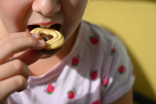 Young girl - child eating candy and sweets. Detail of face and mouth. Concept for healthy lifestyle - healthy - unhealthy sweet food and sugar.