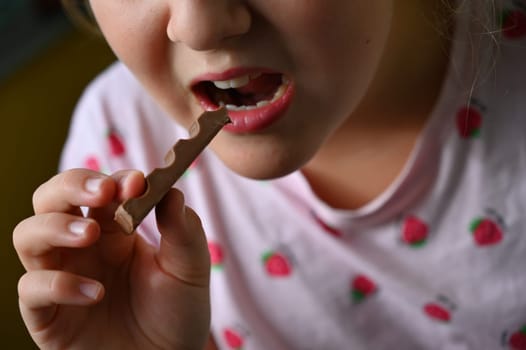 Young girl - child eating candy and sweets. Detail of face and mouth. Concept for healthy lifestyle - healthy - unhealthy sweet food and sugar.