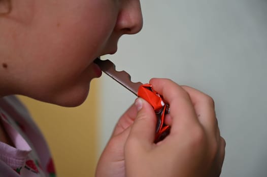 Young girl - child eating candy and sweets. Detail of face and mouth. Concept for healthy lifestyle - healthy - unhealthy sweet food and sugar.