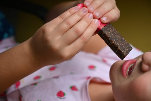 Young girl - child eating candy and sweets. Detail of face and mouth. Concept for healthy lifestyle - healthy - unhealthy sweet food and sugar.