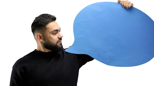 A man, close-up, on a white background, shows a blue comment sign.