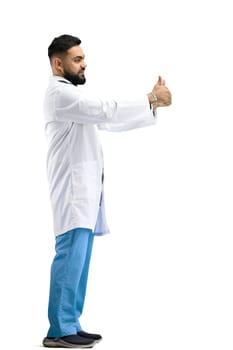 The doctor, in full height, on a white background, shows a thumbs up.