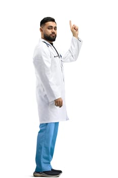 The doctor, in full height, on a white background, shows an important sign.