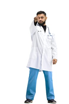 The doctor, in full height, on a white background, points forward.
