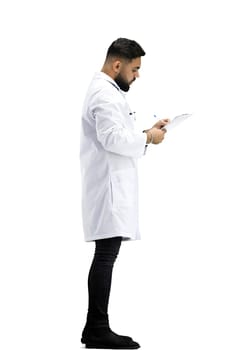 The doctor, in full height, on a white background, writes.
