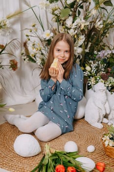 Two girls in a beautiful Easter photo zone with flowers, eggs, chickens and Easter bunnies. Happy Easter holiday