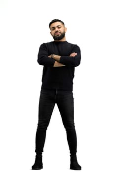 A man, full-length, on a white background, crossed his arms.