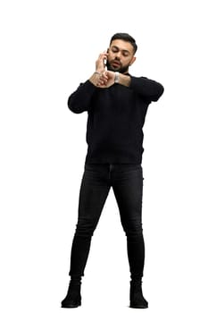 A man, full-length, on a white background, talking on the phone.