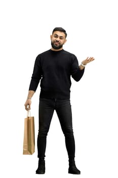 A man, full-length, on a white background, with bags, points to the side.
