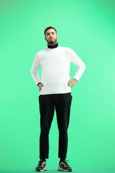 A man, full-length, on a green background, warming up.