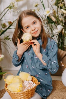 Two girls in a beautiful Easter photo zone with flowers, eggs, chickens and Easter bunnies. Happy Easter holiday