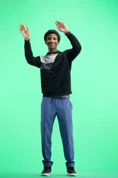 A man, full-length, on a green background, waving his arms.