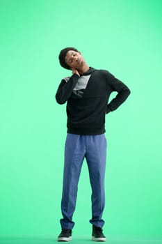 A man, full-length, on a green background, warming up.