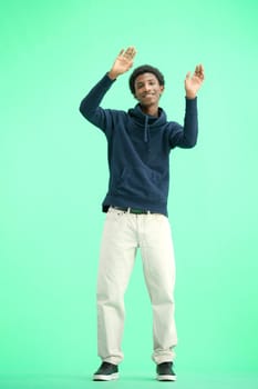 A man, full-length, on a green background, waving his arms.