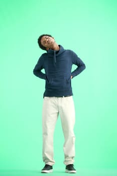 A man, full-length, on a green background, warming up.