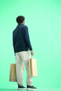 A man, full-length, on a green background, with bags.