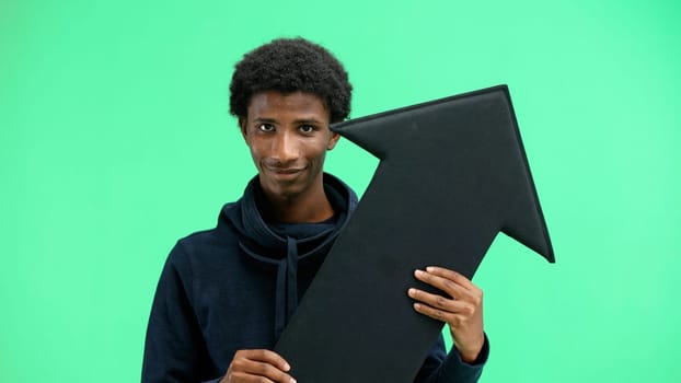 Man, close-up, on a green background, pointing up arrow.