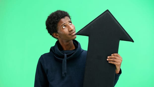 Man, close-up, on a green background, pointing up arrow.