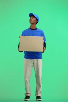 The deliveryman, full-length, on a green background, with a box.