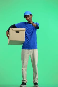 The deliveryman, in full height, on a green background, with a box, shows a thumbs up.