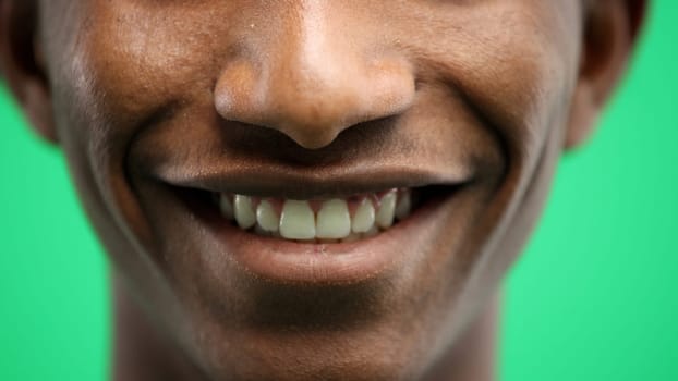 Man's mouth, close-up, on a green background.