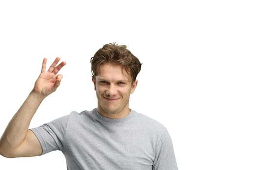 A man, on a white background, in close-up, shows an ok sign.