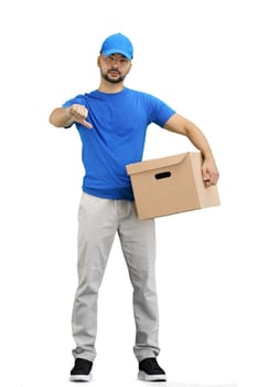 The deliveryman, in full height, on a white background, with a box, shows his finger down.