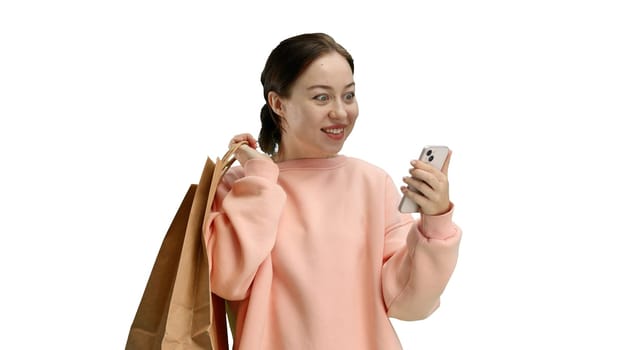 Woman, close-up, on a white background, with bags and a phone.