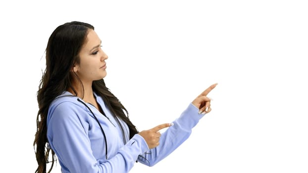 A woman, close-up, on a white background, points to the side.