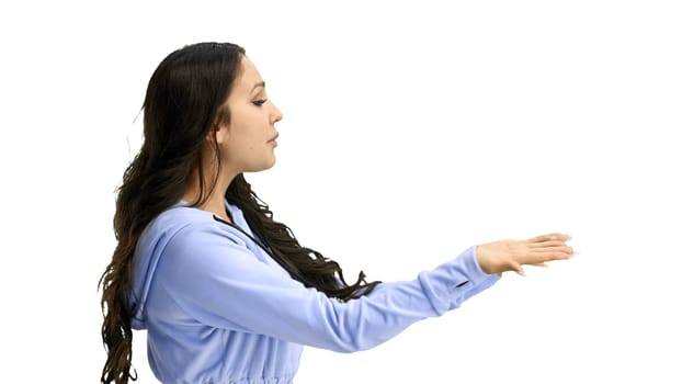 A woman, close-up, on a white background, points to the side.