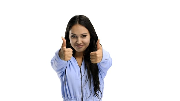 A woman, close-up, on a white background, shows her thumbs up.