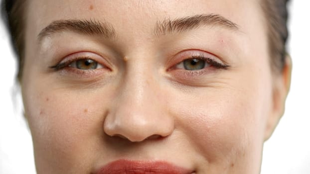 Woman's face, close-up, on a white background.