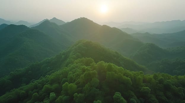 A view of a mountain range with trees and the sun shining