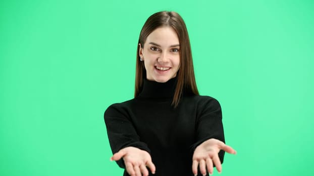 A woman, close-up, on a green background, spreads her arms.